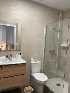 a bathroom with a toilet and a glass shower at Gómez-Tortosa Apartamento in Novelda