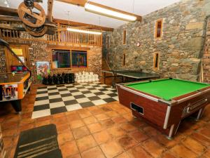 a room with a pool table and a stone wall at Cwellyn in Pwllheli