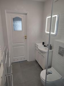 une salle de bain blanche avec toilettes et lavabo dans l'établissement Apartament przy 29 alei, à Cracovie