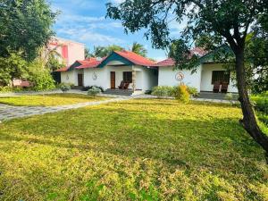 a house with a green lawn in front of it at Srishty Garden Resorts in Tenkāsi
