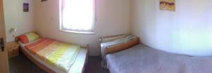 ein kleines Zimmer mit zwei Betten und einem Fenster in der Unterkunft "Marianne" RE20 in Sögel + 3 Fotos