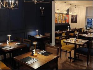 a dining room with tables and chairs in a restaurant at The Bramley House Hotel in Chatteris