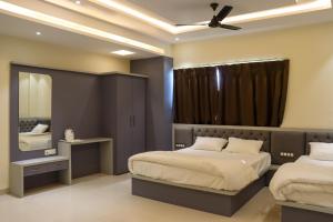 a bedroom with two beds and a mirror at Hotel Panna Shree in Ujjain