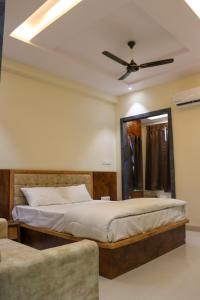a bedroom with a bed and a ceiling fan at Hotel Panna Shree in Ujjain