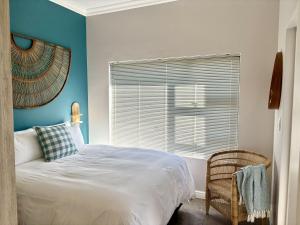 兰格班Casa del Mar - Huisie by die See的一间带床、窗户和椅子的卧室