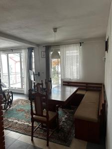 a dining room with a wooden table and a couch at Vila Jovana i Andrea in Mavrovo