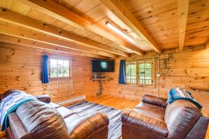 una sala de estar con muebles de cuero en una cabaña de madera en Bellevue Log Cabin with Gas Grill and Creek Access, en Bellevue