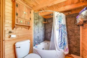 y baño con bañera, aseo y bañera con cortina de ducha. en Bellevue Log Cabin with Gas Grill and Creek Access, en Bellevue 22 fotos más