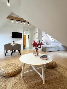 a white living room with a table and a couch at PARKOVA APARTAMENTY - termy, centrum, park in Jelenia Góra