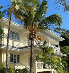 a white house with palm trees in front of it at Spas Villas La Villa in Victoria