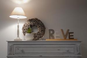 a lamp on top of a dresser with a peace sign at Le Relais De La Motte in Soignies