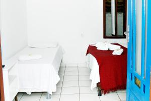 a room with a bed and a table with towels at Vila Mucugê Pousada e Hostel in Arraial d'Ajuda +89 photos