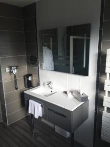 a bathroom with a white sink and a mirror at Logis Auberge Des Moissons in Matougues