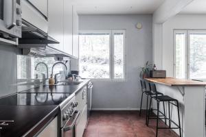 a kitchen with a sink and a counter with stools at Beautiful 1BR Apartment near Lahti Center with Free Parking in Lahti