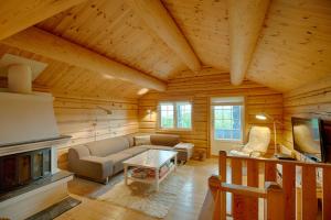 un soggiorno con divano e camino di Peaceful Cabin Close to Beitostølen Center&nature a Beitostøl