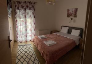a small bedroom with a bed and a window at Sweet Home Mitropoleos in Kastoria