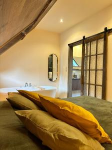 1 dormitorio con lavamanos y 1 cama con almohadas en Le Ruisseau Gîte Idéal pour un Séjour à Deux au Fil de l'Eau, en Vireux-Wallerand
