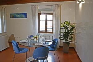 a dining room with a table and blue chairs at Maison B in Prato +8 photos