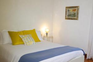 a bed with yellow and blue pillows in a room at Maison B in Prato