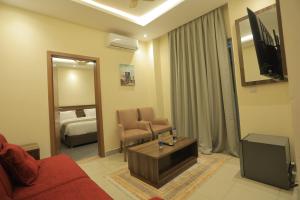 a living room with a red couch and a television at Sharaf Hotel Dire Dawa in Dirē Dawa