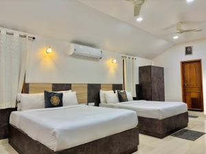 zwei Betten in einem Hotelzimmer mit zwei Betten in der Unterkunft Riyavar Luxury Stay in Siddapur + 27 Fotos