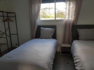 una piccola camera da letto con due letti e una finestra di Maison entre CHU et Cézeaux- Parking gratuit a Beaumont