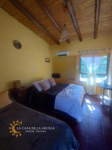 a bedroom with two beds and a window at La Casa de la Abuela Tilcara in Tilcara