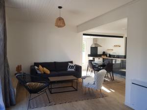 un soggiorno con un divano e un tavolo di Maison entre CHU et Cézeaux- Parking gratuit a Beaumont