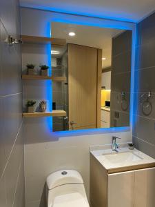 a bathroom with a mirror and a toilet and a sink at Espectacular loft con club house! in Bogotá