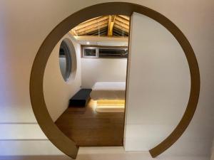 a circular mirror on a wall with a bed in a room at Hyu Stay in Gyeongju +80 photos