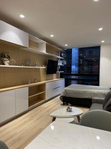 a living room with a bed and a table at Espectacular loft con club house! in Bogotá
