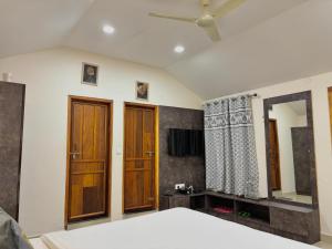 a bedroom with a bed and a mirror at Riyavar Luxury Stay in Siddapur