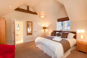 1 dormitorio con 1 cama grande y 1 silla roja en Dbs Serviced Apartments en Castle Donington