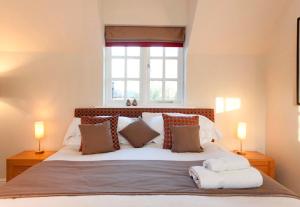 a bed with a white comforter and pillows on it at Dbs Serviced Apartments in Castle Donington