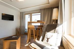 a living room with a chair and a table at Berghotel Schlossanger Alp in Pfronten