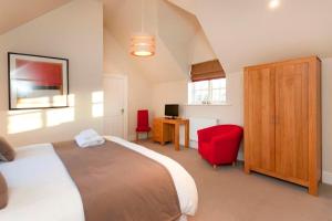 a bedroom with a bed, chair and a television at Dbs Serviced Apartments in Castle Donington