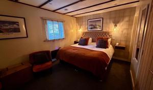 a bedroom with a large bed and a window at Lochindaal Hotel in Port Charlotte
