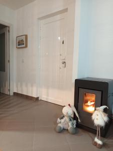 two stuffed animals sitting in front of a fireplace at Apartamento O lago in Valdoviño