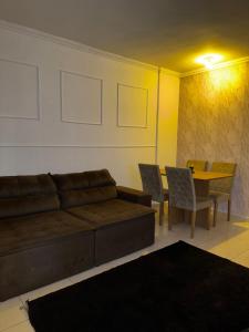 a living room with a couch and a table with chairs at Casa Refúgio Para o Paraíso in Rio das Ostras