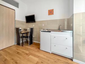 a kitchen with a sink and a counter with a table at Studio lumineux avec clim et TV idéal pour couples in Aix-les-Bains