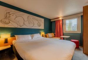 une chambre d'hôtel avec un grand lit et une fenêtre dans l'établissement B&B HOTEL Lille Villeneuve d'Ascq Grand Stade, à Villeneuve d'Ascq