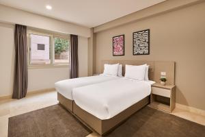 a bedroom with a large white bed and a window at Brassbell l New Cairo l next to AUC in Cairo