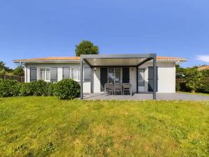 Una casa blanca con un gran jardín delante de ella. en Villa Elisa in Andernos-les-Bains, en Andernos-les-Bains