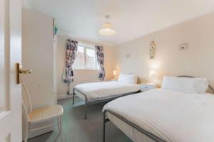 En eller flere senge i et værelse på High Tide - Norfolk Cottage Agency