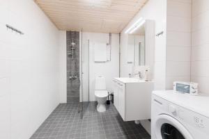 a white bathroom with a toilet and a shower at Forenom Serviced Apartments Vantaa Neilikkatie in Vantaa +41 photos