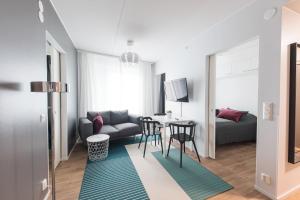 a living room with a couch and a table at Forenom Serviced Apartments Vantaa Neilikkatie in Vantaa