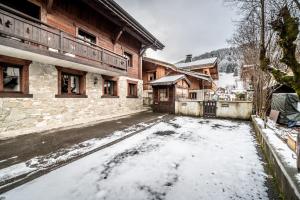 una calle cubierta de nieve frente a un edificio en LES SERMES M304, en Morzine