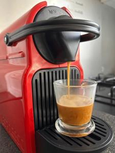 a coffee maker is pouring a cup of coffee at Charmant F2 au cœur de Royat in Royat +4 photos