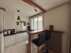 a kitchen with white cabinets and a wooden counter top at Charmant F2 au cœur de Royat in Royat