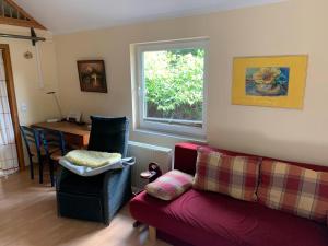 a living room with a red couch and a window at Ferienhaus Loubier Marne in Marne